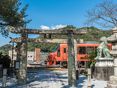 神社の目の前を電車が走っている様子の写真
