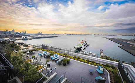 横浜の海が一望でき、中央には大きな船も見えるルーフトップテラス昼間の写真