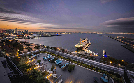 横浜の海が一望でき、中央には大きな船も見えるルーフトップテラス夜景の写真