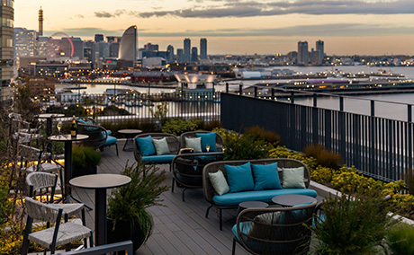 奥に夕刻の横浜の街並みが見えるルーフトップテラスの写真