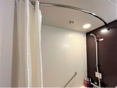 【バスルーム】カーテンレールが湾曲しており、カーテンが体に付きにくい工夫が施されています。