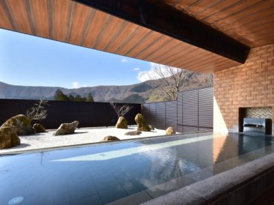 【露天風呂】2025年3月1日庭園を枯山水にリニューアル。箱根寄木細工をモチーフとした壁面が特徴的。