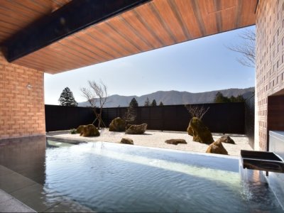 【露天風呂】2025年3月1日庭園を枯山水にリニューアル。箱根寄木細工をモチーフとした壁面が特徴的。