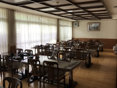 朝食会場　１階にある食堂　現在はテーブル間にパーテーションを設置しています。