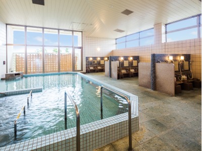 大浴場（男湯）　超軟水（硬度7）を使用した湯は温泉のように柔らかく、保湿効果が高いと好評です。旅の疲れを広々とした大浴場でのんびり癒やしてください。